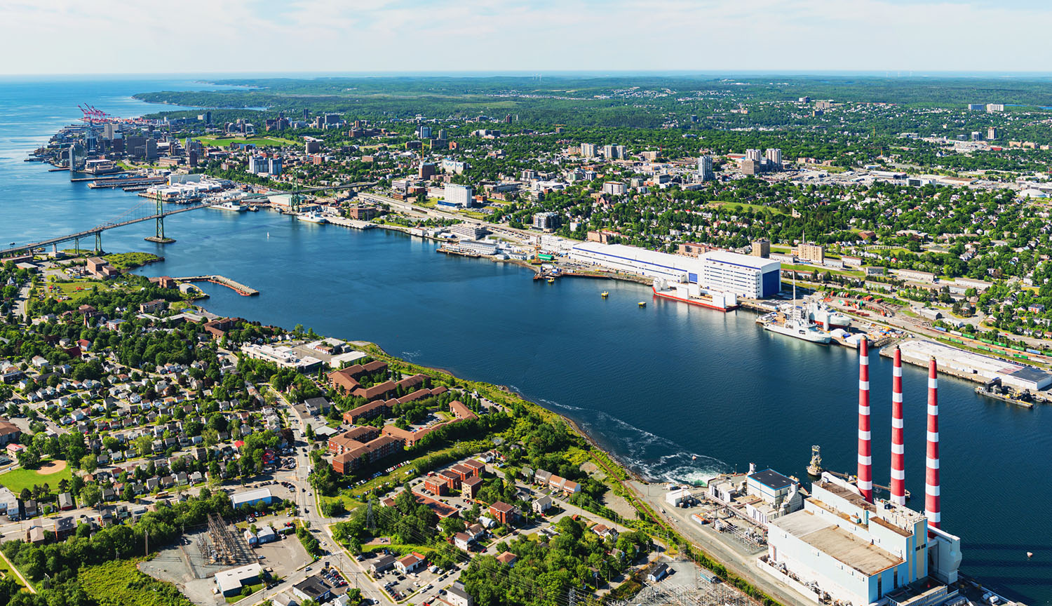 Halifax harbor with smokestacks of a power plant in foreground.
