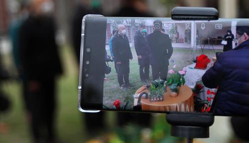 Photograph of a smartphone livestreaming a burial.