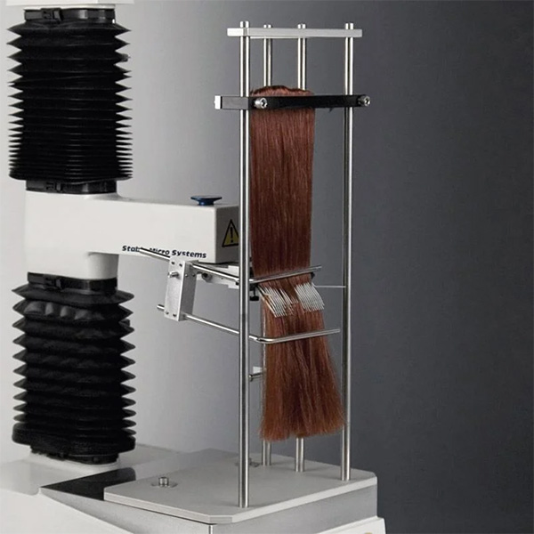 A device that measures the force required to comb through a mass of hair held with a clamp.