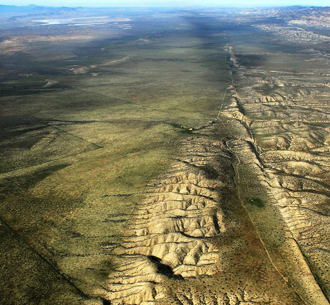 Aerial photo of the San Andreas fault shows a dramatic, straight indentation in the land heading off into the distance.
