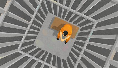 Bird’s eye view of person sitting alone in a prison cell.