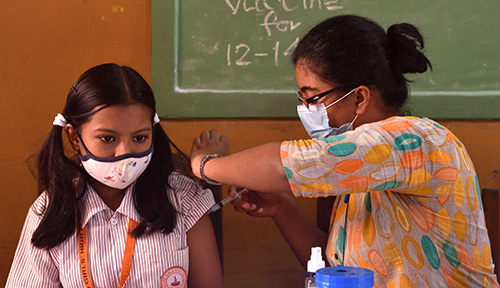 A girl receives a vaccination from a health-care professional.